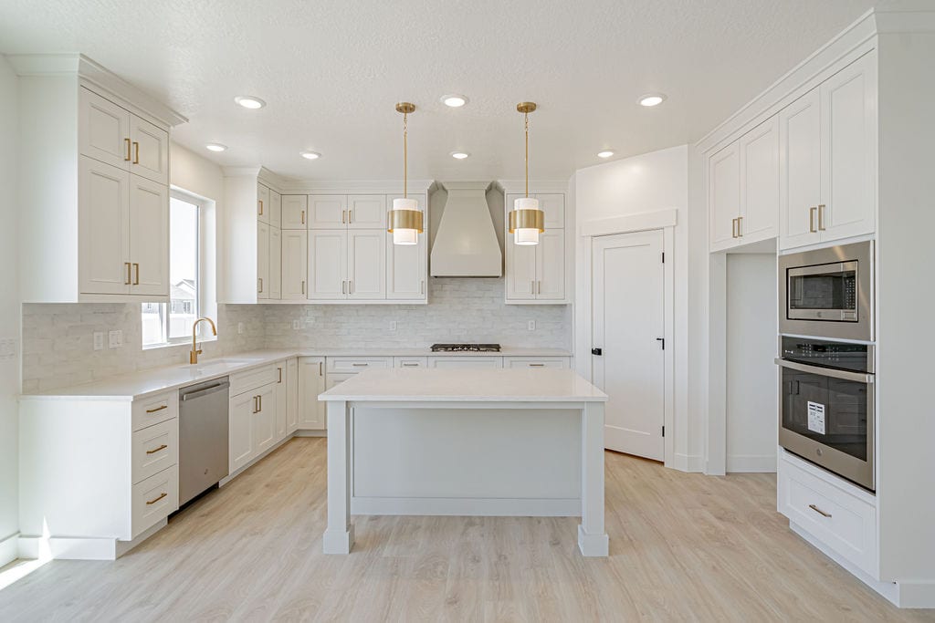 A bright white kitchen with island and pantry